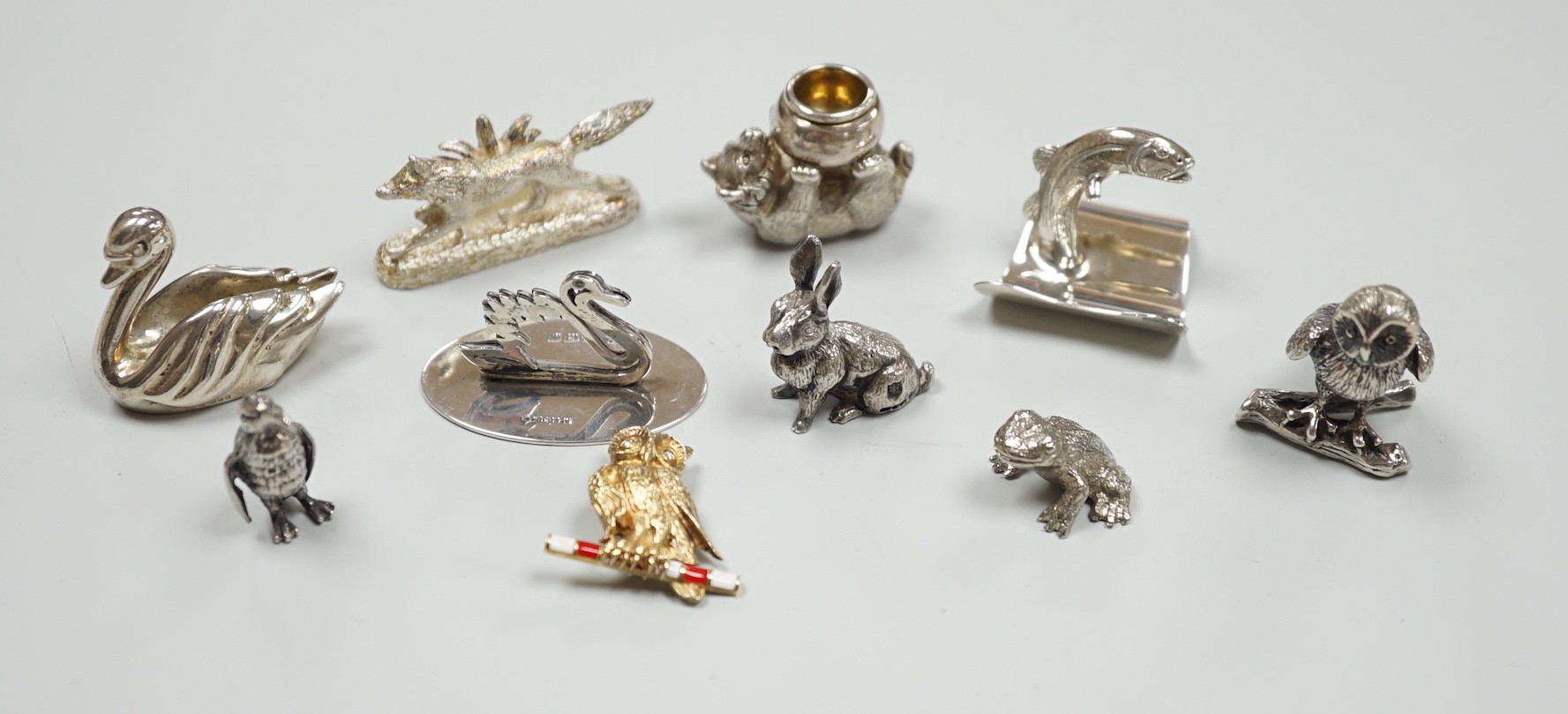 Eight assorted modern silver miniature animal or bird figures including menu holders, including rabbit by Tessiers Ltd, height 27mm, an earlier silver swan menu holder and a silver gilt owl brooch.